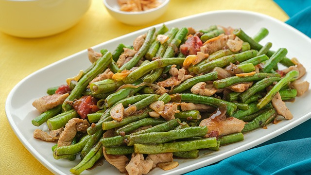 adobong sitaw with chicken on a white rectangular plate