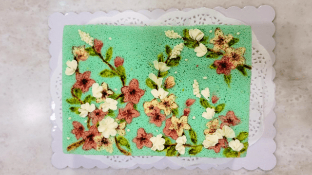 BBakery's handpainted chiffon cake, designed with sakura blossoms on a teal background